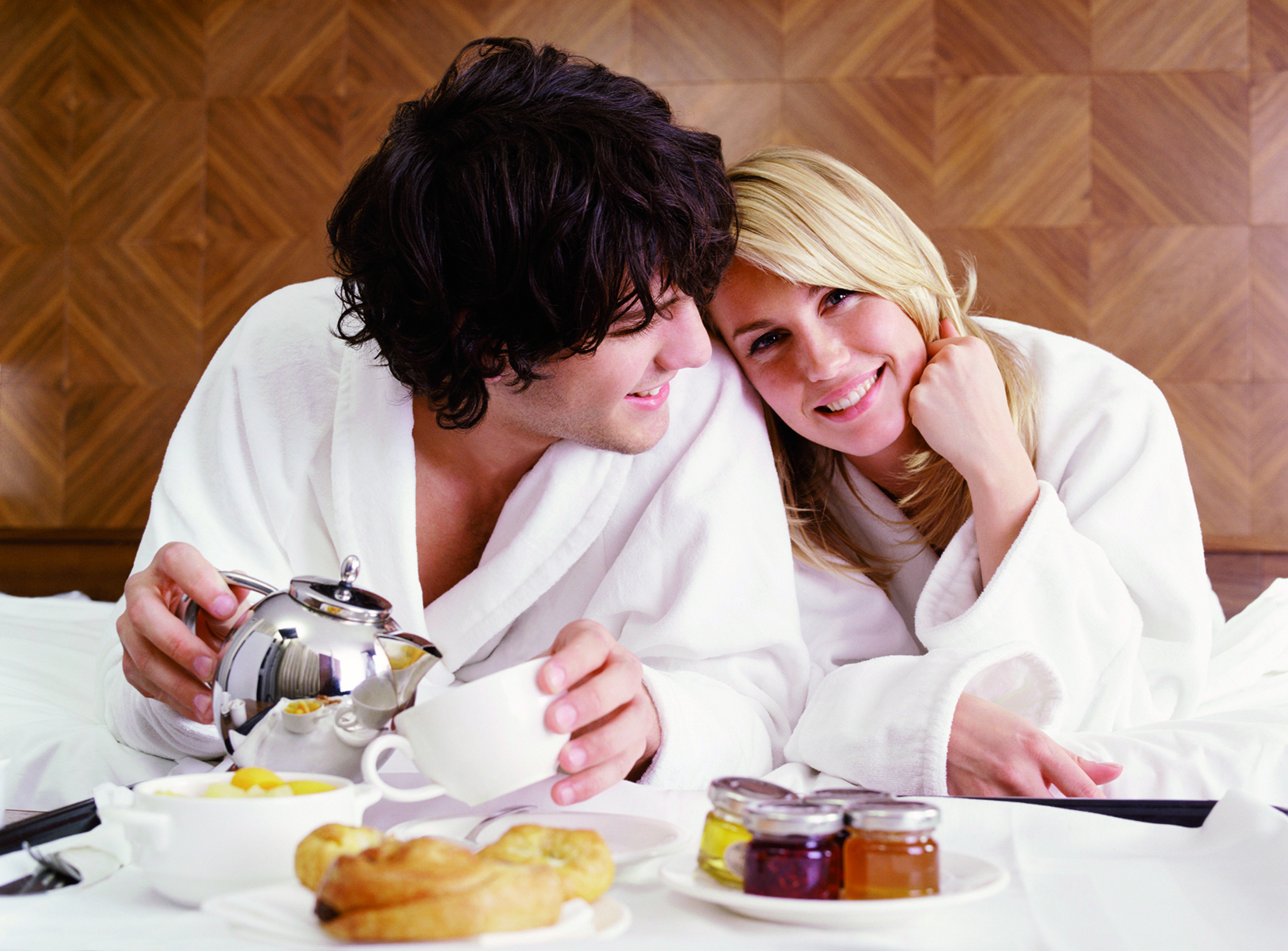 Fr&uuml;hst&uuml;ck im Bett mit Tee und Geb&auml;ck, zwei Personen in Badem&auml;nteln