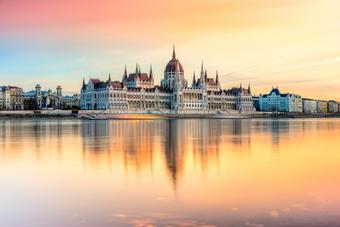 Budapest mit Parlament, Donau und Sonnenuntergangshimmel in warmen Farben.