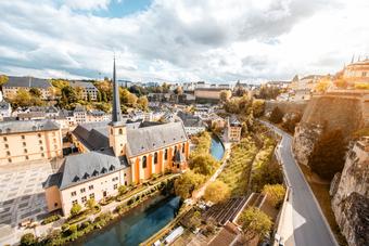 Luxemburg mit Alzette-Fluss, historischen Gebäuden und grüner Stadtlandschaft.
