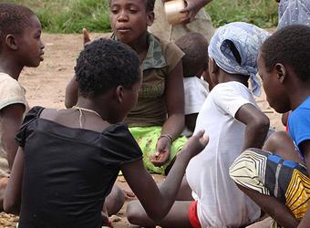 Gruppe von Menschen sitzt gemeinsam im Freien und unterhält sich.