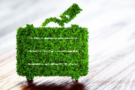 A suitcase made of green foliage symbolizes eco-friendly and sustainable travel.