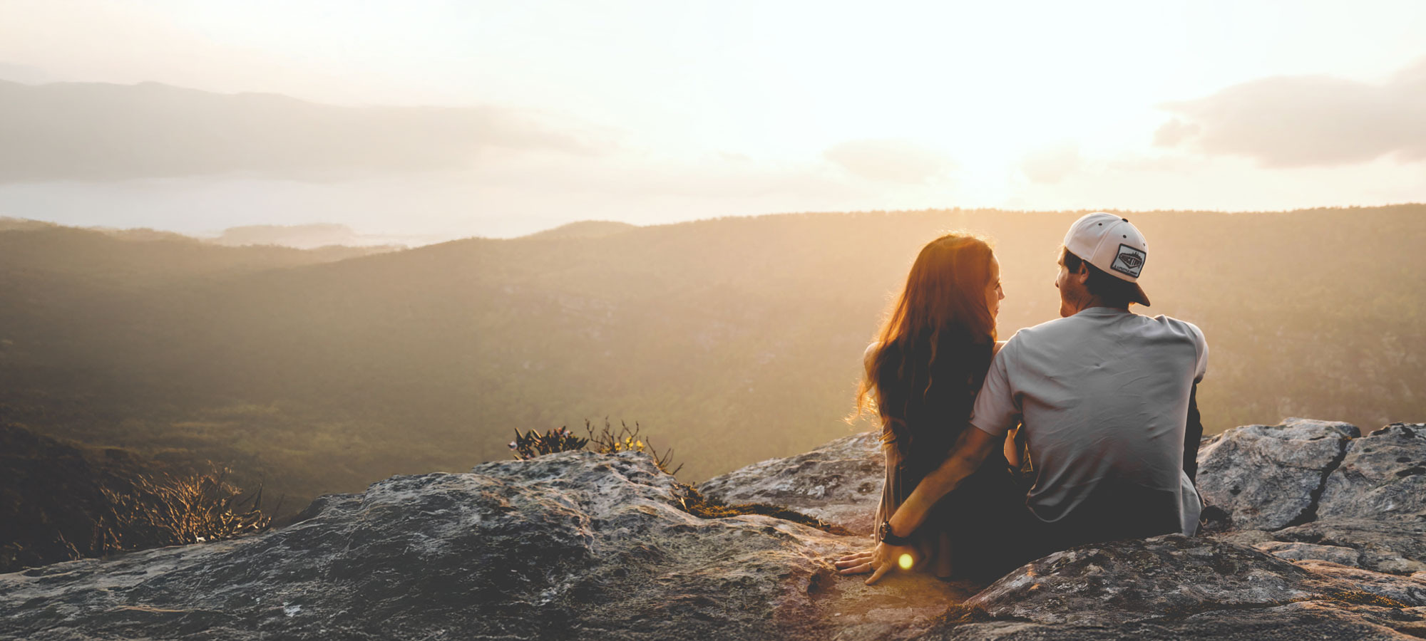 Woman and man sitting together on a rock