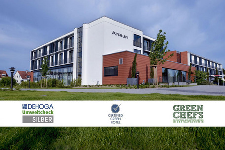 Modernes Hotelgebäude mit Umwelt- und Nachhaltigkeitssiegeln.