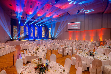 Elegantly set event hall with stage and light show.